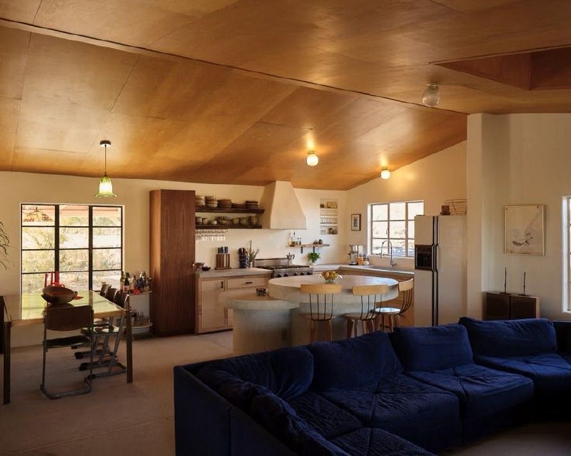 Wide shot of the finished kitchen featuring custom concrete island and wood ceiling