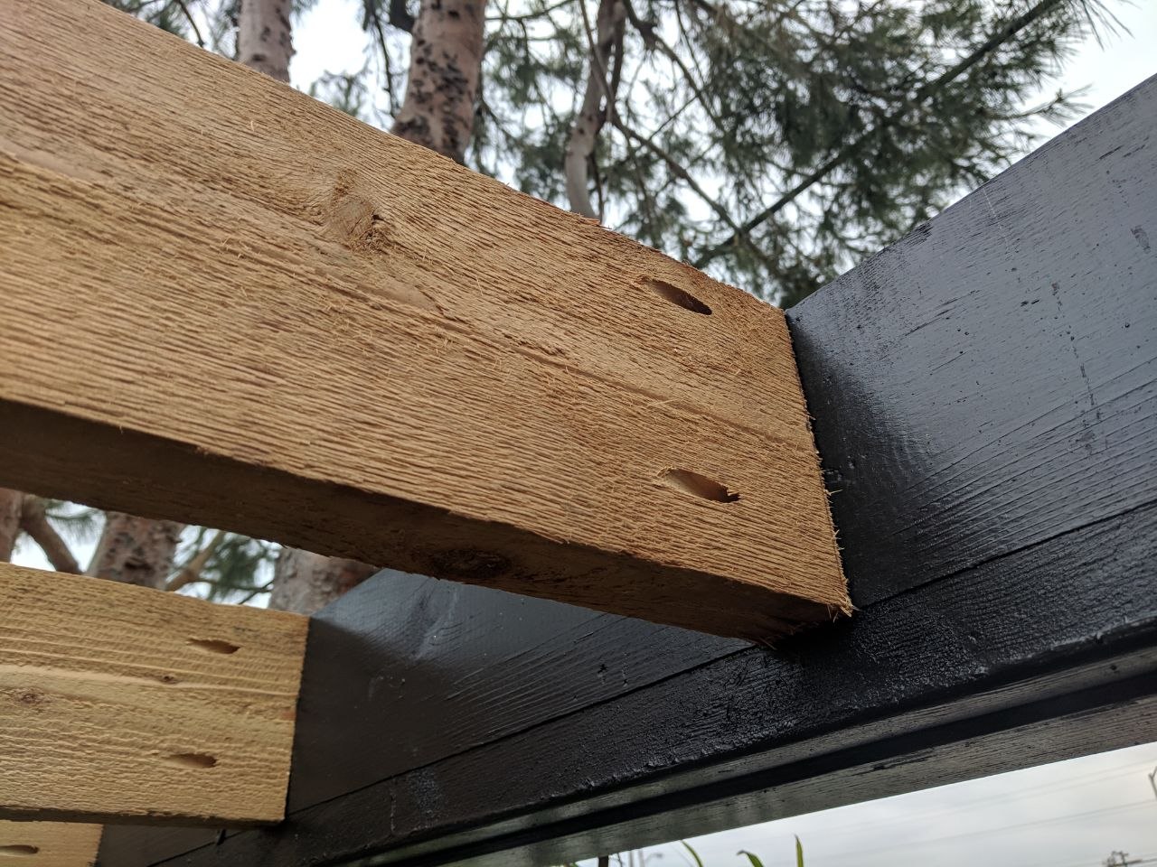 Custom wood and steel beam joinery on pergola